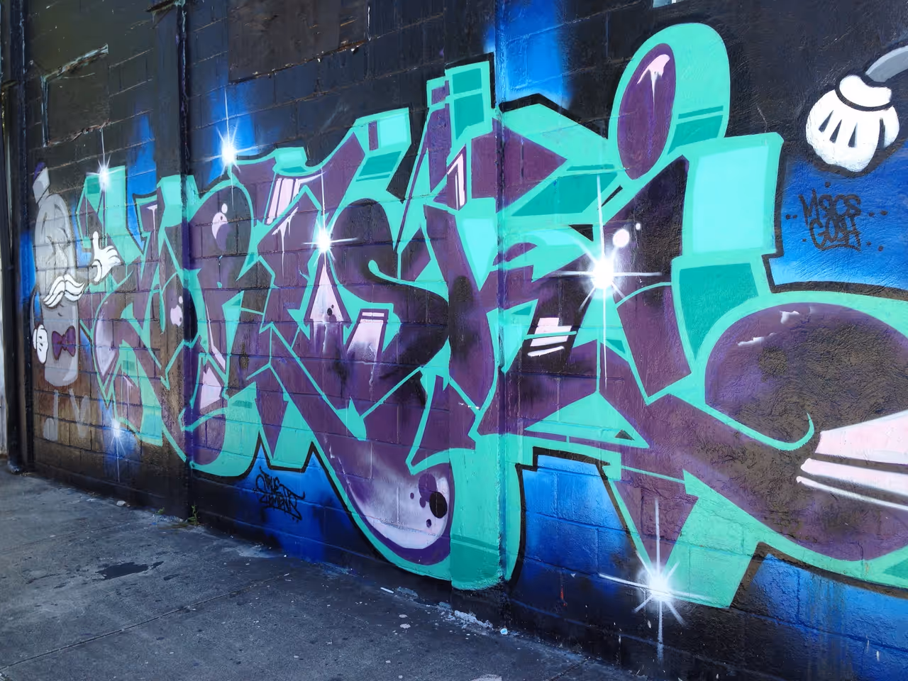 Vibrant graffiti wall art featuring bold green and purple street lettering in the Wynwood Art District