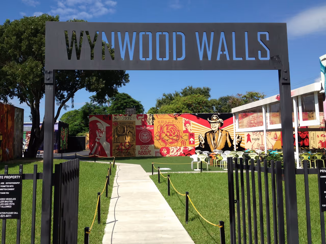 Entrance sign to the Wynwood Walls outdoor street art museum in Miami, Florida featuring colourful murals in the background