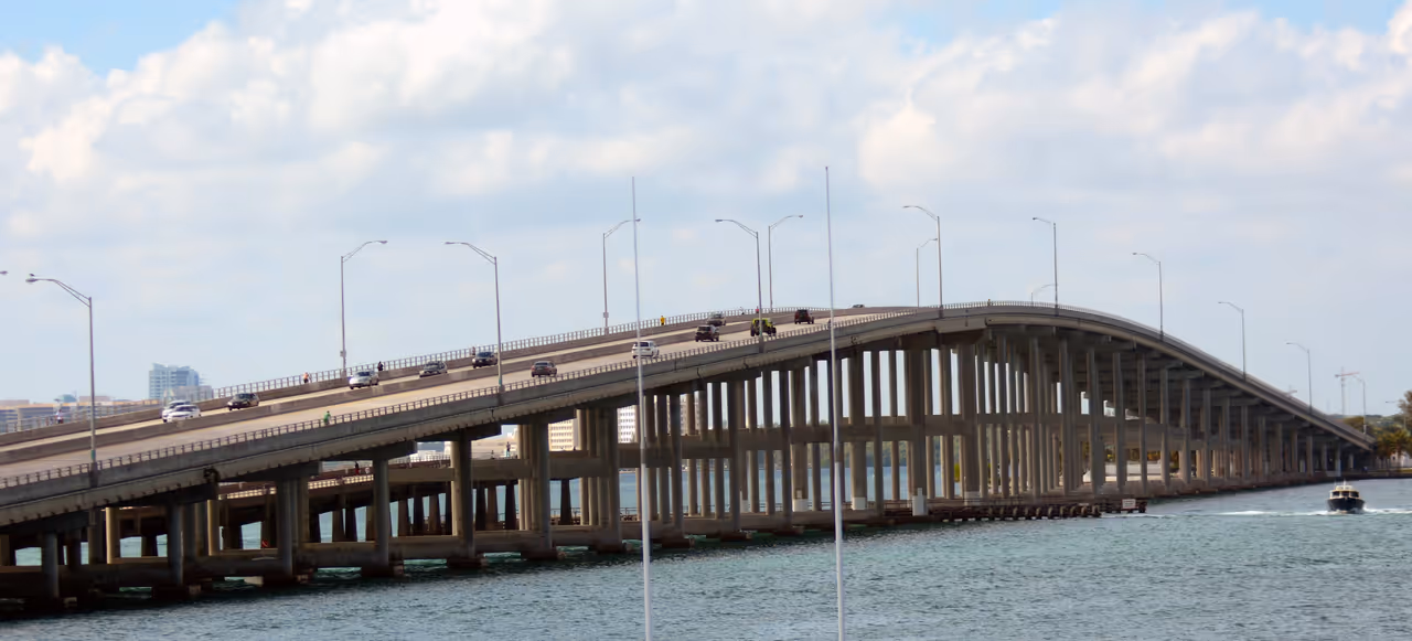 Rickenbacker Causeway bridge with cars driving over the water under a cloudy sky in Miami