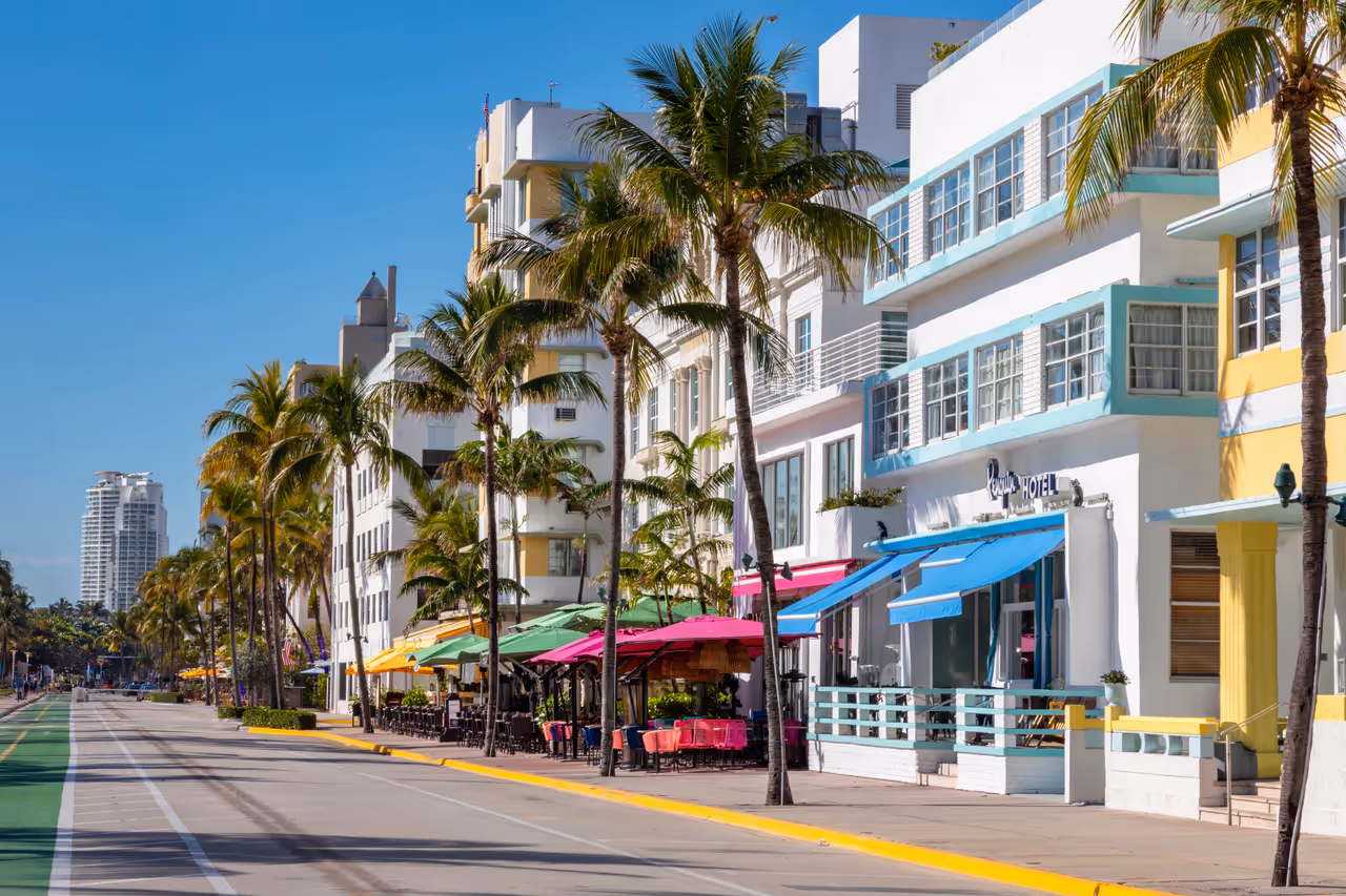 Historic Art Deco hotels and outdoor cafes along Ocean Drive in South Beach, Miami, lined with palm trees and a pedestrian promenade